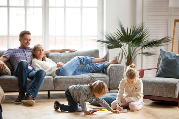 Famille avec enfants dans un salon, détendue et heureuse