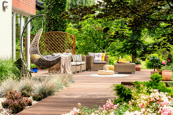 Très beau jardin avec fleurs, arbres, canapé et hamac