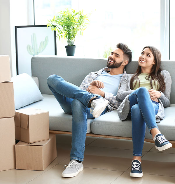 Couple assis sur un canapé heureux après un déménagement