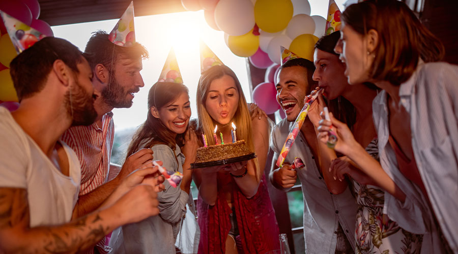 Groupe amis femmes hommes fête anniversaire avec gâteau et bougies