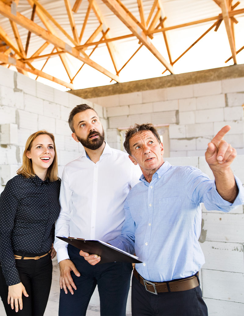 Conducteur travaux avec couple clients dans maison en construction