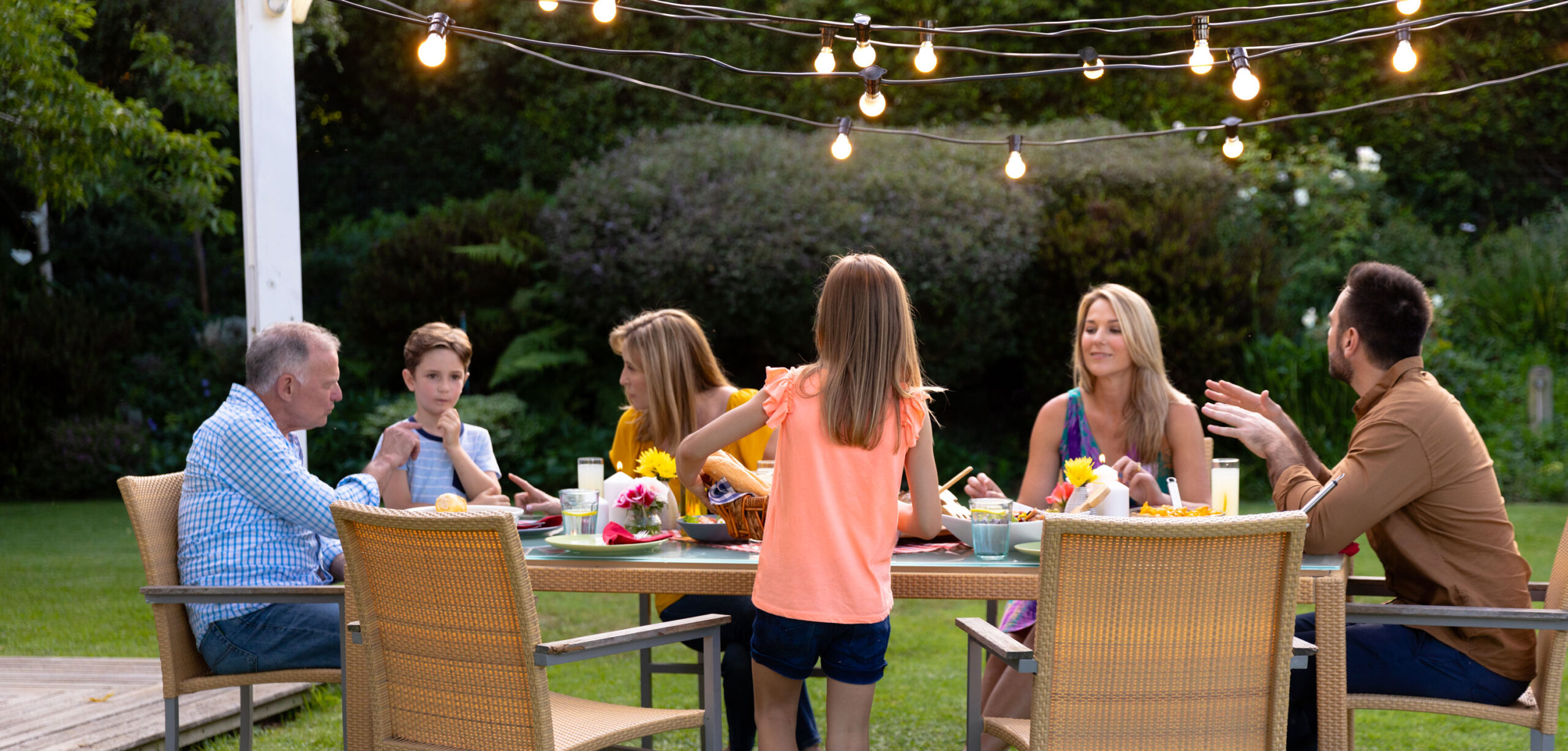 Famille dans un jardin prenant le repas éclairage