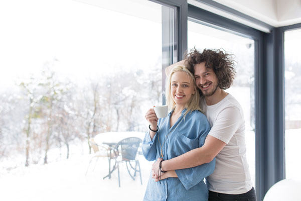 Isolation maison passive couple fenêtre jardin neige