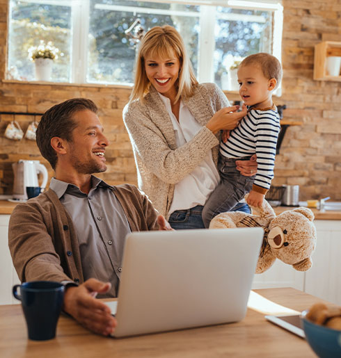 Famille dans leur cuisine devant un ordinateur