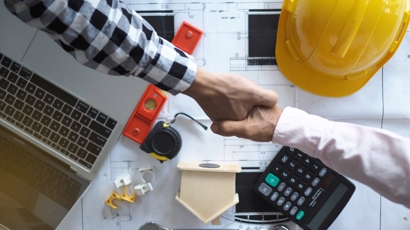 Un client et un entrepreneur qui s'accordent pour la construction d'une maison en forme de U